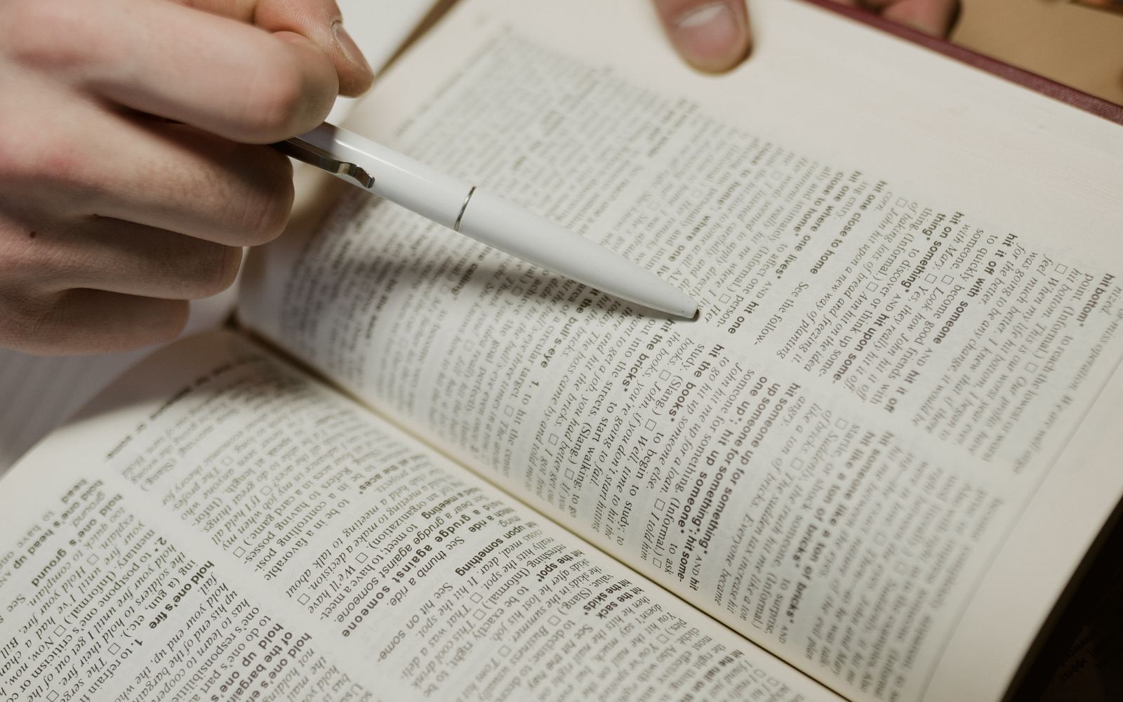 A close-up of an editor annotating a printed page with a pen