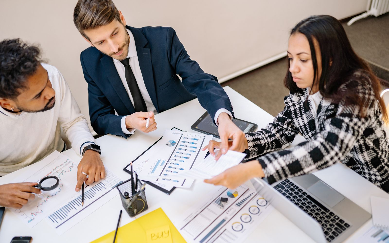 An editorial team reviewing printed pages and notes together around a meeting table